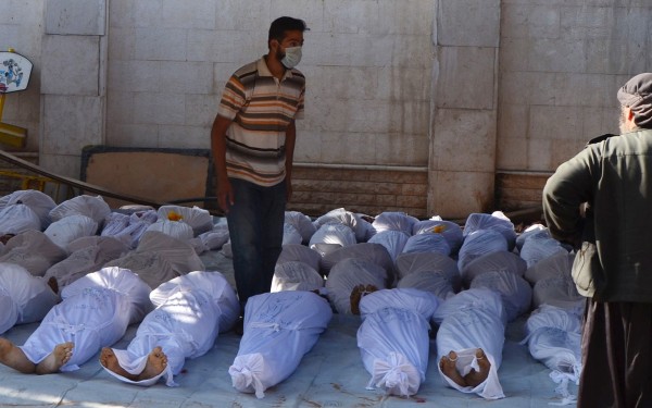 Syrian activists inspect the bodies of people they say were killed by nerve gas in the Ghouta region, in the Duma neighbourhood of Damascus