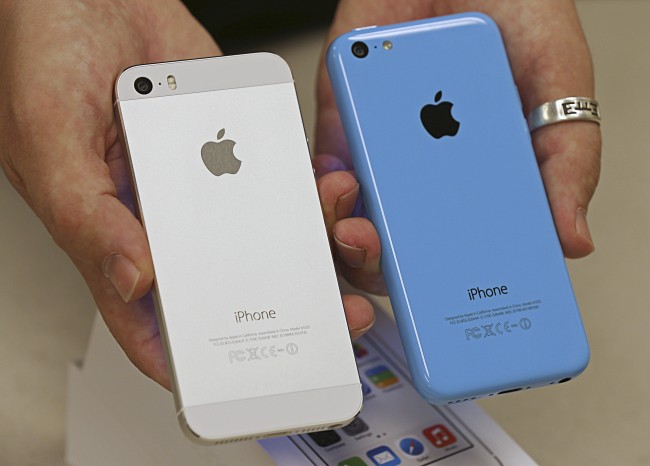An employee shows the the backside of a new Apple iPhone 5C and iPhone 5 S at a Verizon store in Orem, Utah