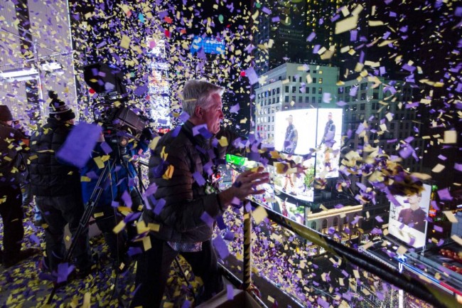 Confetti engineer Norm Larsen tosses confetti onto revellers from the roof of the Marriott Marquis hotel during New Year's Eve celebrations in Times Square in New York