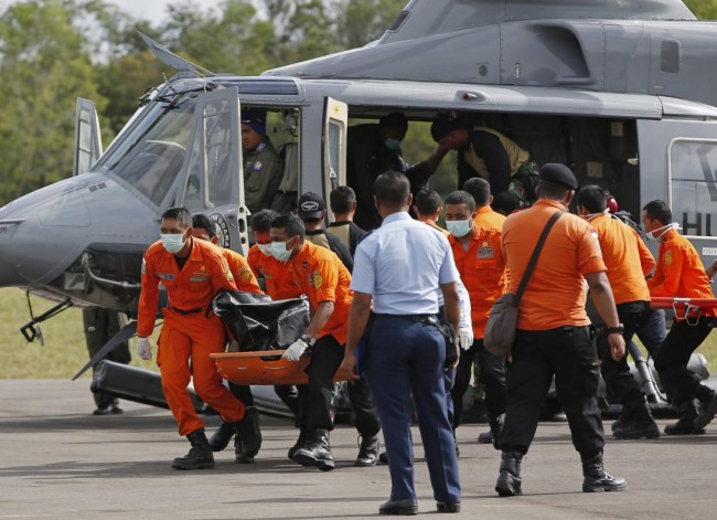 Indonesian Search and Rescue crew unload one of two bodies of AirAsia passengers recovered from the sea at the airport in Pangkalan Bun, Central Kalimantan