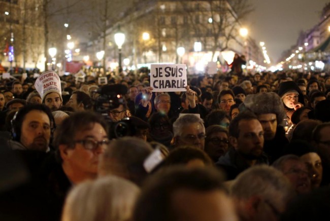 A man holds a placard reading "I am Charlie" as he attends a vigil to pay tribute to the victims of a shooting by gunmen at the offices of weekly satirical magazine Charlie Hebdo in Paris at Republique square