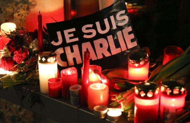 Candles and a placard which reads "I am Charlie" are pictured as tributes to victims of the Charlie Hebdo shooting, at the French embassy at Pariser Platz in Berlin