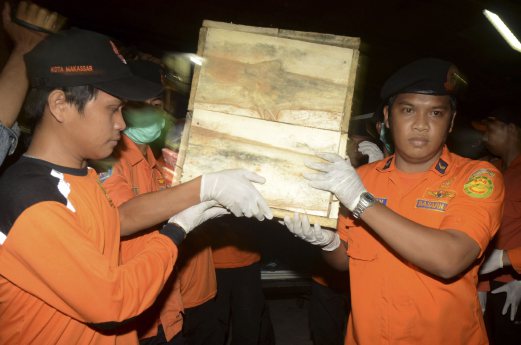 Antara Foto shows Indonesian search and rescue members unloading a casket carrying the suspected remains of one of seven AirAsia QZ8501 passengers recently recovered off the coast of Sulawesi in Makassar