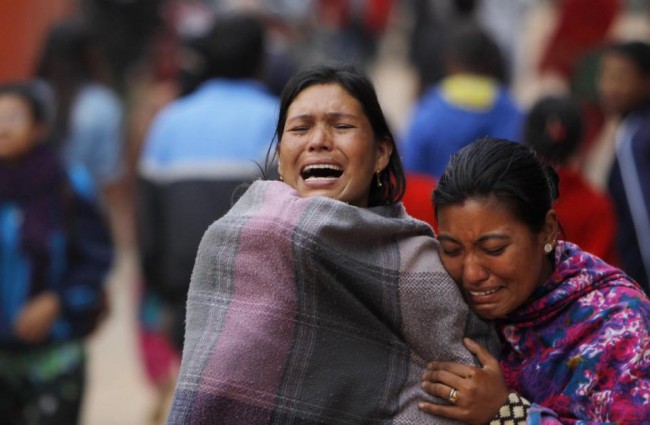 Family members break down during the cremation of an earthquake victim in Bhaktapur near Kathmandu, Nepal, Sunday, April 26, 2015. A strong magnitude 7.8 earthquake shook Nepal's capital and the densely populated Kathmandu Valley before noon Saturday, causing extensive damage with toppled walls and collapsed buildings, officials said. (AP Photo/Niranjan Shrestha)