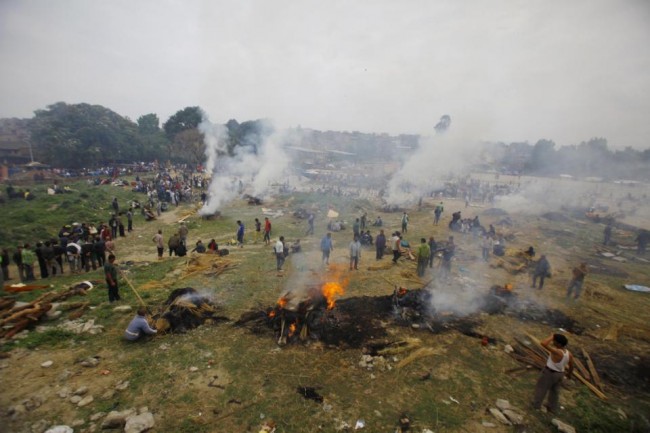 Nepalese people gather to cremate their family members who died in the earthquake in Bhaktapur near Kathmandu, Nepal, Sunday, April 26, 2015. A strong magnitude 7.8 earthquake shook Nepal's capital and the densely populated Kathmandu Valley before noon Saturday, causing extensive damage with toppled walls and collapsed buildings, officials said. (AP Photo/Niranjan Shrestha)