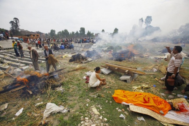 Nepalese people gather to cremate family members who fell victim to Saturday's earthquake, in Bhaktapur, Nepal, Sunday, April 26, 2015. A powerful, magnitude 6.7 aftershock shook the Kathmandu area of Nepal on Sunday, a day after the massive earthquake devastated the region and destroyed homes and infrastructure. (AP Photo/Niranjan Shrestha)