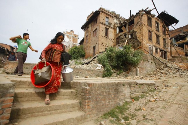 Nepalese evacuate with belongings to safer areas in Bhaktapur, Nepal, Sunday, April 26, 2015. A powerful, magnitude 6.7 aftershock shook the Kathmandu area of Nepal on Sunday, a day after the massive earthquake devastated the region and destroyed homes and infrastructure. (AP Photo/Niranjan Shrestha)