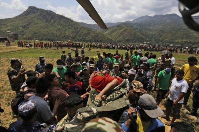 Nepalese soldiers carry a wounded woman to a waiting Indian air force helicopter as they evacuate victims of Saturdays earthquake from Trishuli Bazar to Kathmandu airport in Nepal, Monday, April 27, 2015. The death toll from Nepal's earthquake is expected to rise depended largely on the condition of vulnerable mountain villages that rescue workers were still struggling to reach two days after the disaster.  (AP Photo/Altaf Qadri)