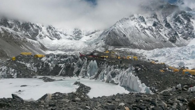 A rescue chopper prepares to land, carrying people from higher camps to Everest Base Camp, Nepal, Monday, April 27, 2015. An avalanche on Saturday, set off by the massive earthquake that struck Nepal, left more than a dozen people dead and dozens more injured. (AP Photo/Nima Namgyal Sherpa)