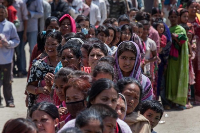 KATHMANDU, NEPAL - APRIL 27:  Residents line up for food in an evacuation area set up by the authorities in Tundhikel park on April 27, 2015 in Kathmandu, Nepal. A major 7.8 earthquake hit Kathmandu mid-day on Saturday, and was followed by multiple aftershocks that triggered avalanches on Mt. Everest that buried mountain climbers in their base camps. Many houses, buildings and temples in the capital were destroyed during the earthquake, leaving over 3000 dead and many more trapped under the debris as emergency rescue workers attempt to clear debris and find survivors.  (Photo by Omar Havana/Getty Images)