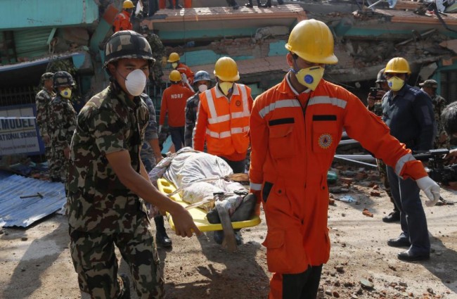 Rescue teams carry a body dug out of the collapsed Sitapyla church in Kathmandu, Nepal, Monday, April 27, 2015. A strong magnitude 7.8 earthquake shook Nepal's capital and the densely populated Kathmandu Valley on Saturday, causing extensive damage with toppled walls and collapsed buildings. (AP Photo/Wally Santana)