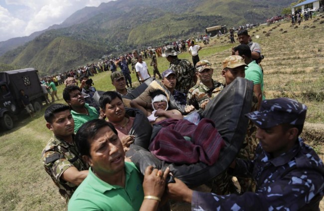 Nepalese soldiers carry a wounded man on a makeshift stretcher to a waiting Indian air force helicopter as they evacuate victims of Saturdays earthquake from Trishuli Bazar to Kathmandu airport in Nepal, Monday, April 27, 2015. The death toll from Nepal's earthquake is expected to rise depended largely on the condition of vulnerable mountain villages that rescue workers were still struggling to reach two days after the disaster.  (AP Photo/Altaf Qadri)