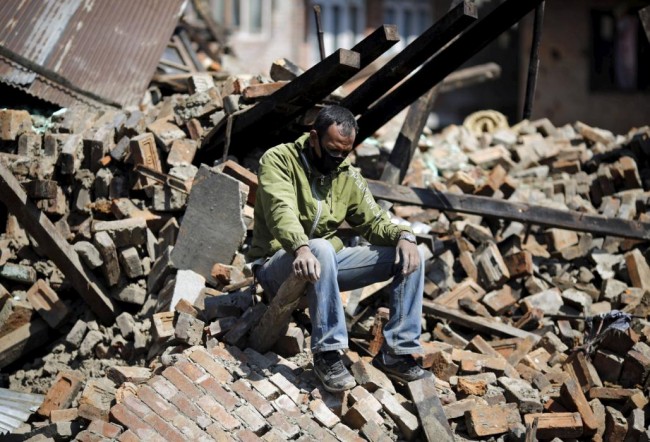A man sits on the rubble of his damaged house following Saturday's earthquake in Bhaktapur, Nepal April 27, 2015. REUTERS/Adnan Abidi