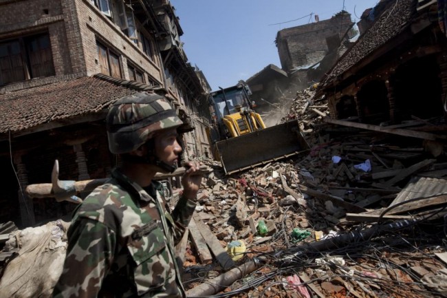 A member of the Nepalese army walks through a damaged area caused by Saturday's earthquake, in Bhaktapur on the outskirts of Kathmandu, Nepal, Monday, April 27, 2015. A strong magnitude earthquake shook Nepals capital and the densely populated Kathmandu valley on Saturday devastating the region and leaving tens of thousands shell-shocked and sleeping in streets. (AP Photo/Niranjan Shrestha)
