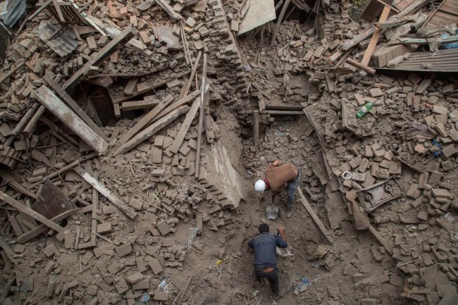 Two men help clear debris after buildings collapsed on April 26, 2015 in Bhaktapur, Nepal. (Omar Havana/Getty Images)