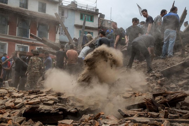 Emergency workers and bystanders clear debris while searching for survivors under a collapsed temple in Basantapur Durbar Square following an earthquake on April 25, 2015 in Kathmandu, Nepal. (Photo by Omar Havana/Getty Images)