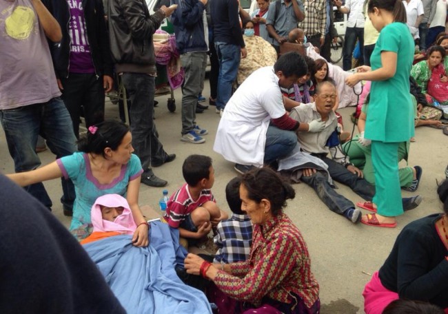 An injured man receives treatment outside the Medicare Hospital in Kathmandu, Nepal, Saturday, April 25, 2015. A strong magnitude-7.9 earthquake shook Nepal's capital and the densely populated Kathmandu Valley before noon Saturday, causing extensive damage with toppled walls and collapsed buildings, officials said. (AP Photo/ Niranjan Shrestha)