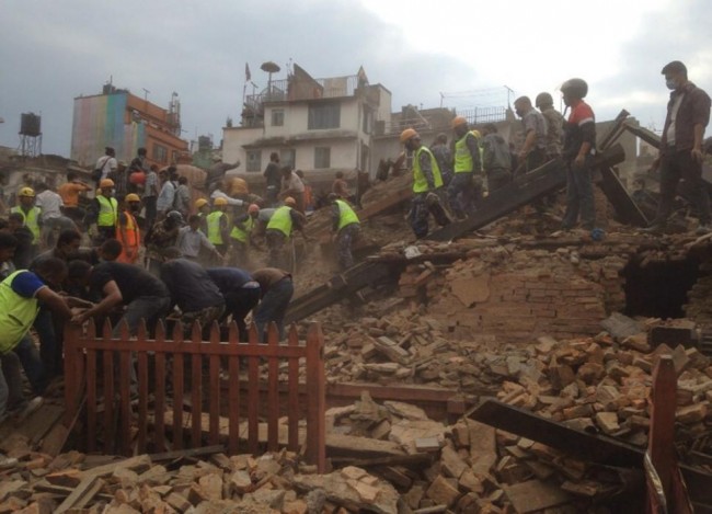 Rescuers clear the debris at Durbar Sqaure after an earthquake in Kathmandu, Nepal, Saturday, April 25, 2015. A strong magnitude-7.9 earthquake shook Nepal's capital and the densely populated Kathmandu Valley before noon Saturday, causing extensive damage with toppled walls and collapsed buildings, officials said. (AP Photo/ Niranjan Shrestha)