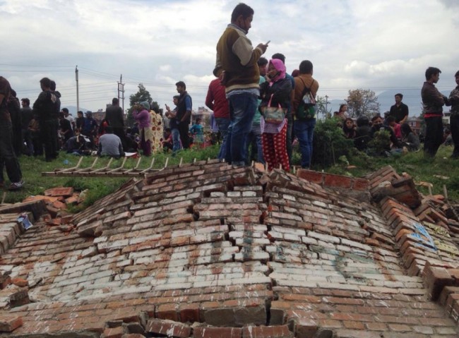 A group of people gather outdoors as an earthquake hits Kathmandu city, Nepal, Saturday, April 25, 2015. A strong magnitude-7.9 earthquake shook Nepal's capital and the densely populated Kathmandu Valley before noon Saturday, causing extensive damage with toppled walls and collapsed buildings, officials said. (AP Photo/ Niranjan Shrestha)