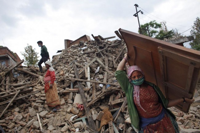 Nepalese earthquake-affected victims salvage belongings from their damaged homes in Lalitpur, on the outskirts of Kathmandu, Nepal, Thursday, April 30, 2015. In mere seconds, Saturdays earthquake devastated a swathe of Nepal. Three of the seven World Heritage sites in the Kathmandu Valley have been severely damaged, including Durbar Square with pagodas and temples dating from the 15th to 18th centuries, according to UNESCO, the United Nations cultural agency. (AP Photo/Niranjan Shrestha)