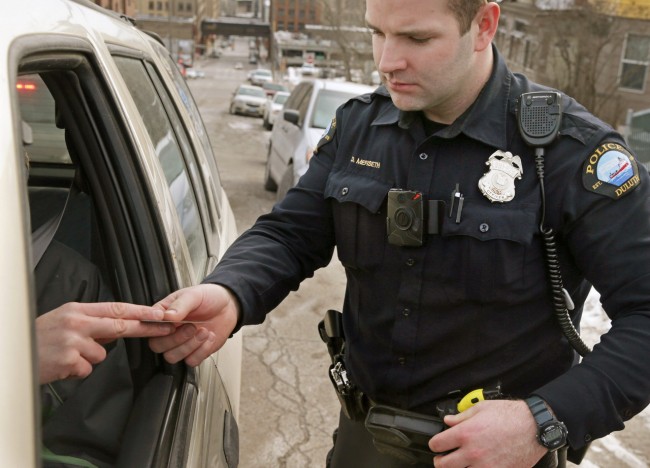 In this Feb. 2, 2015 photo, a red light on the body camera worn on Duluth, Minn. police officer Dan Merseth's uniform indicates it is active during a traffic stop in Duluth. The the city’s 110 officer-worn cameras are generating 8,000 to 10,000 videos per month that are kept for at least 30 days and in many cases longer, says Police Chief Gordon Ramsay. (AP Photo/Jim Mone)